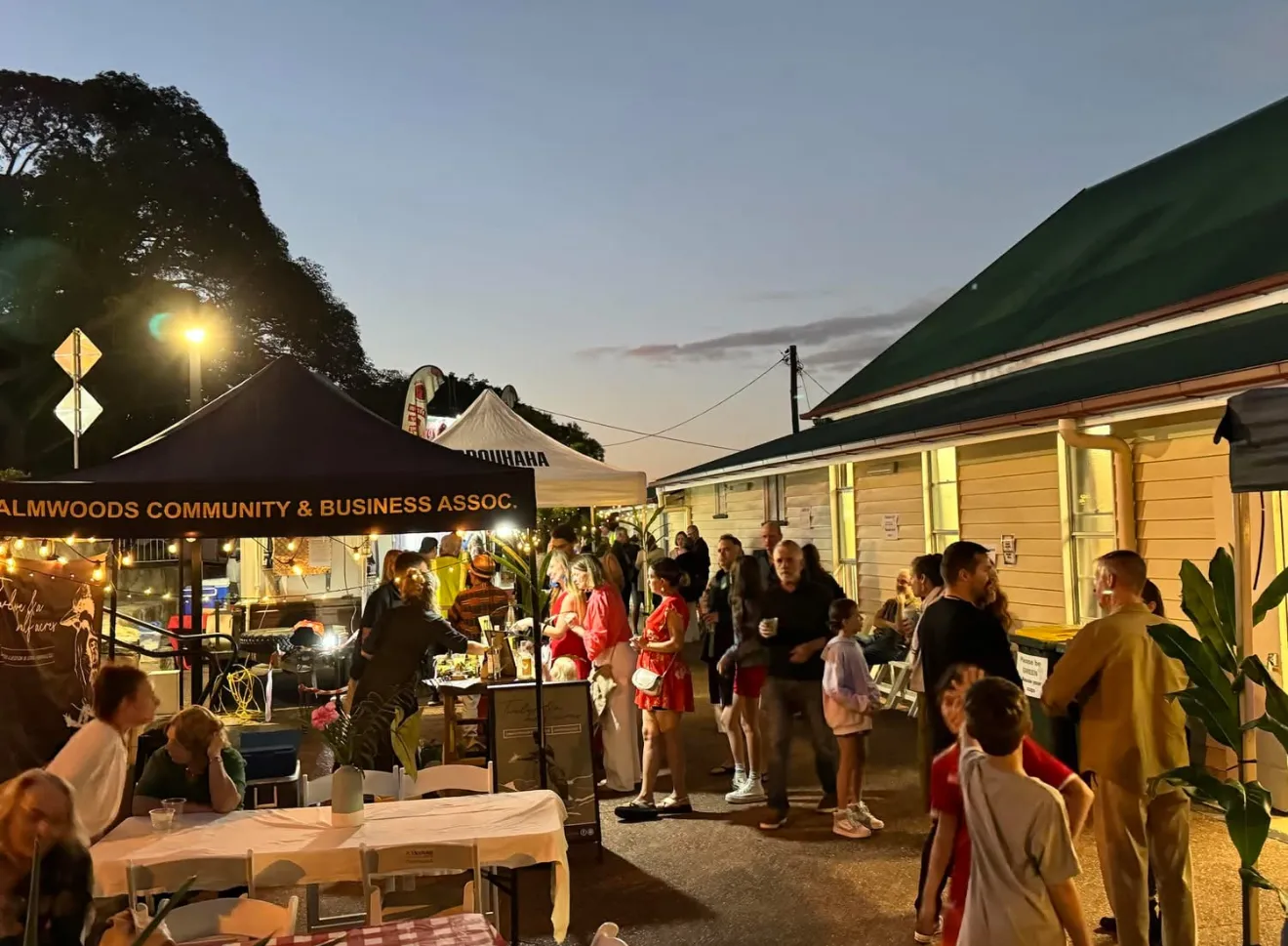 Locals gathered at a Palmwoods market night under the PCBA marquee